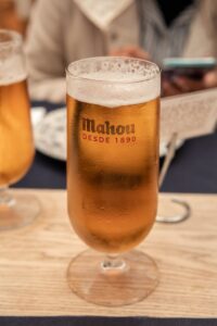 Chilled Mahou beer glass on a wooden table, perfect for a refreshing break.