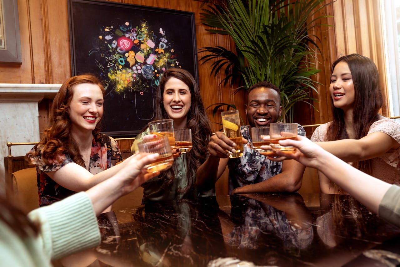 Friends enjoy a vibrant gathering with drinks, laughter, and camaraderie indoors.