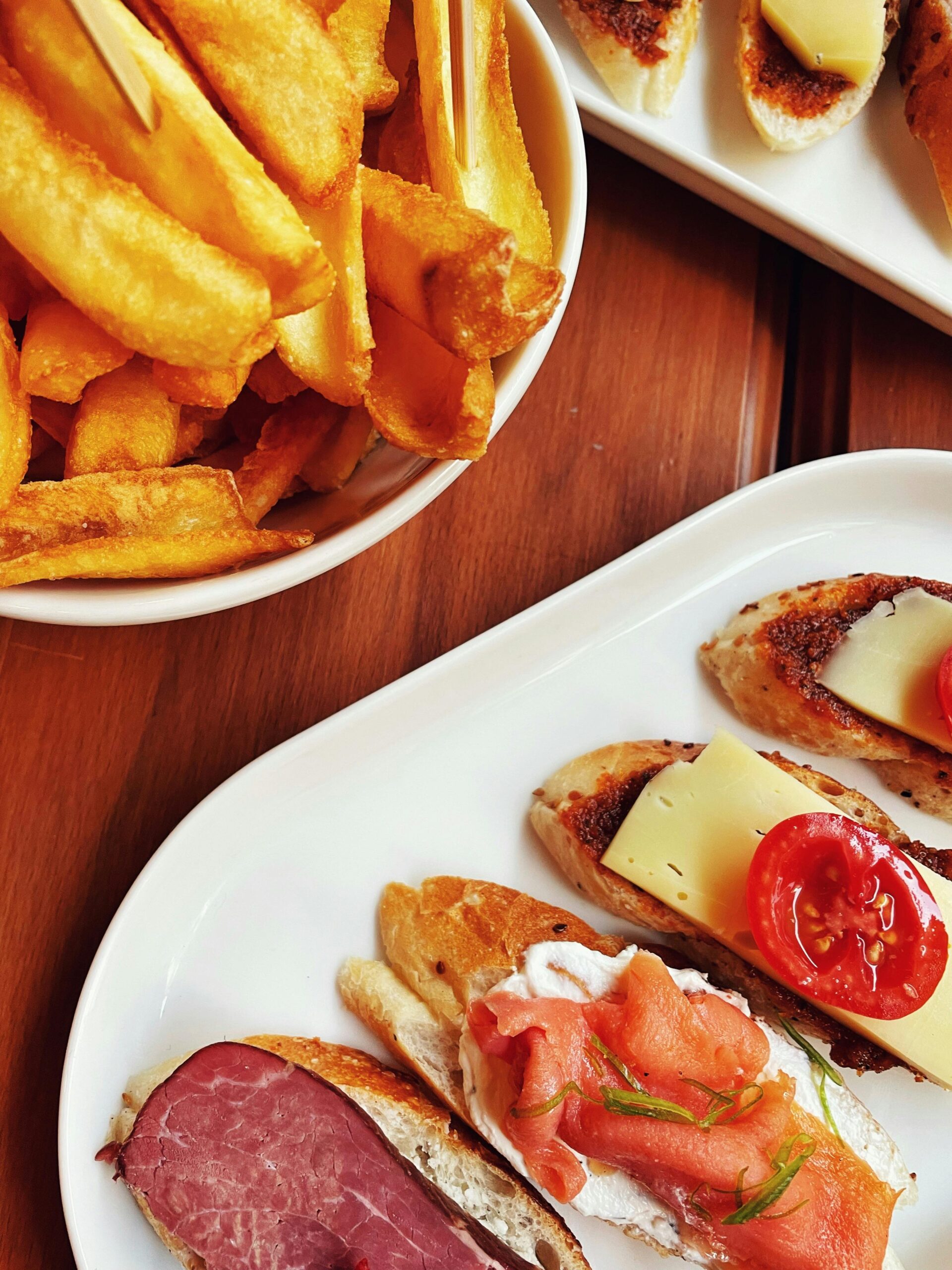 A variety of tasty tapas with fresh toppings served alongside crispy French fries.
