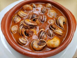 A delicious bowl of Spanish caracoles in rich sauce, showcasing traditional Spanish cuisine.