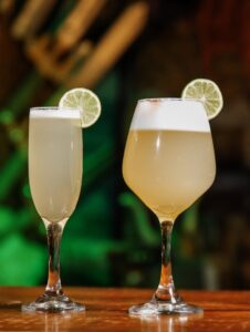 Two refreshing lime cocktails in elegant glasses with a blurred background.
