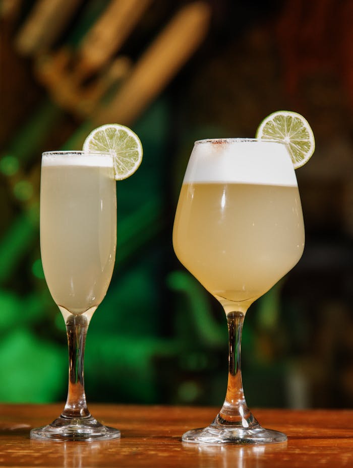Two refreshing lime cocktails in elegant glasses with a blurred background.