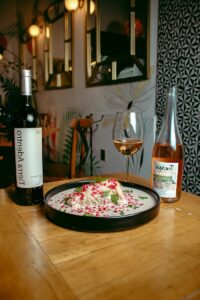 Stylish restaurant scene with gourmet dish, wine, and chic décor.