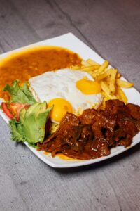 Mouthwatering Lomo a lo Pobre with fried eggs, fries, and avocado slices.