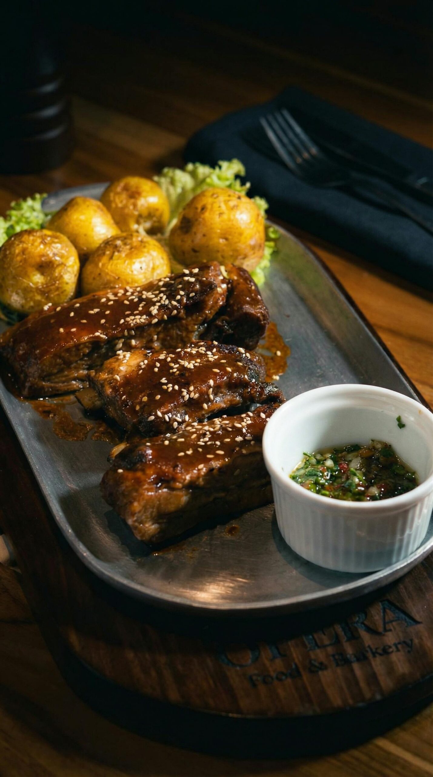 A savory Colombian barbecue dish featuring ribs, roasted potatoes, and salsa, perfect for a gastronomic delight.