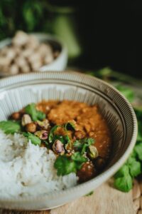 Delicious vegan dahl and rice bowl garnished with cilantro and pistachios, perfect for a healthy meal.