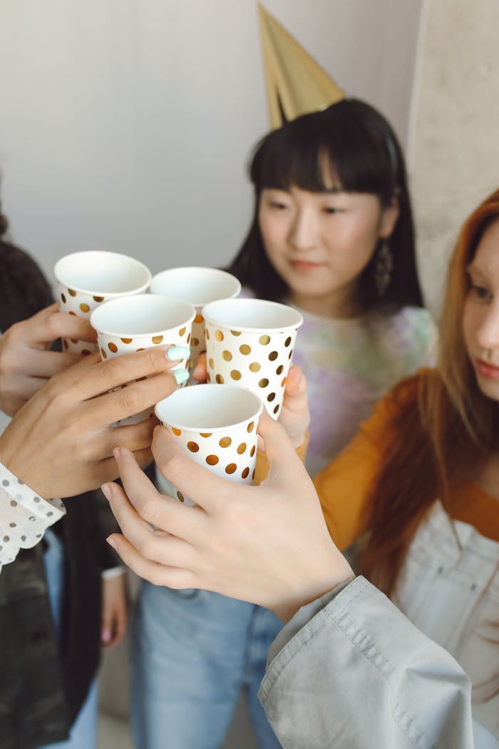 A group of friends toasting with polka dot cups at a celebration.