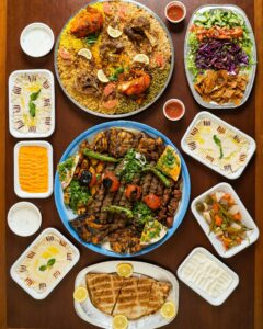 An array of Middle Eastern dishes including grilled meats, rice, and dips in a visually appealing flatlay.
